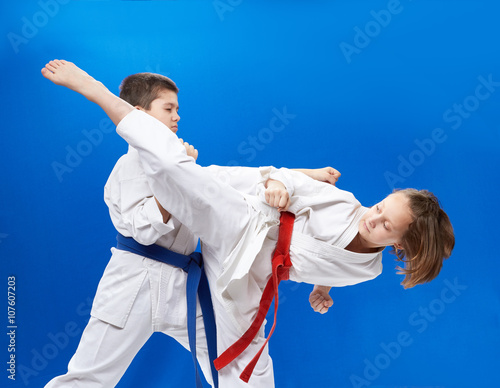 Girl and boy in karategi are training karate blows