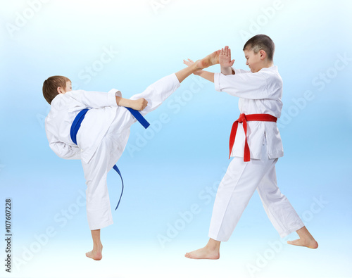 High kick and block are training boys in karategi 