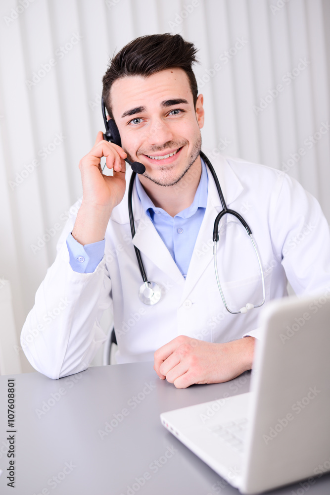 handsome young doctor on the phone at medical emergency call center handsome young doctor on the phone at medical emergency call center