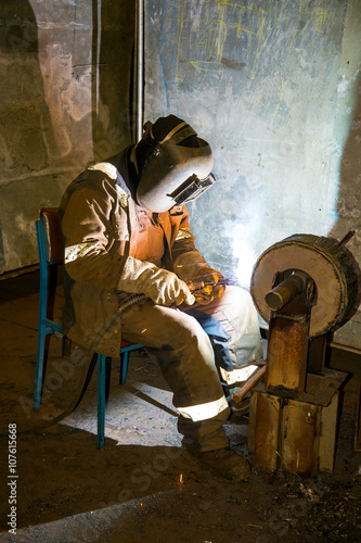 Mig Welder welding metal wheel of the ship cover of the cargo hold