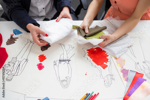 Fotografie Close-up photo of two fashion designers working at new collection