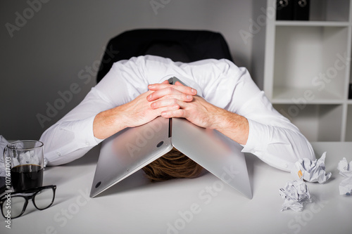 Man hiding under laptop photo