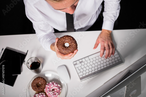 Man at the office eating donuts photo