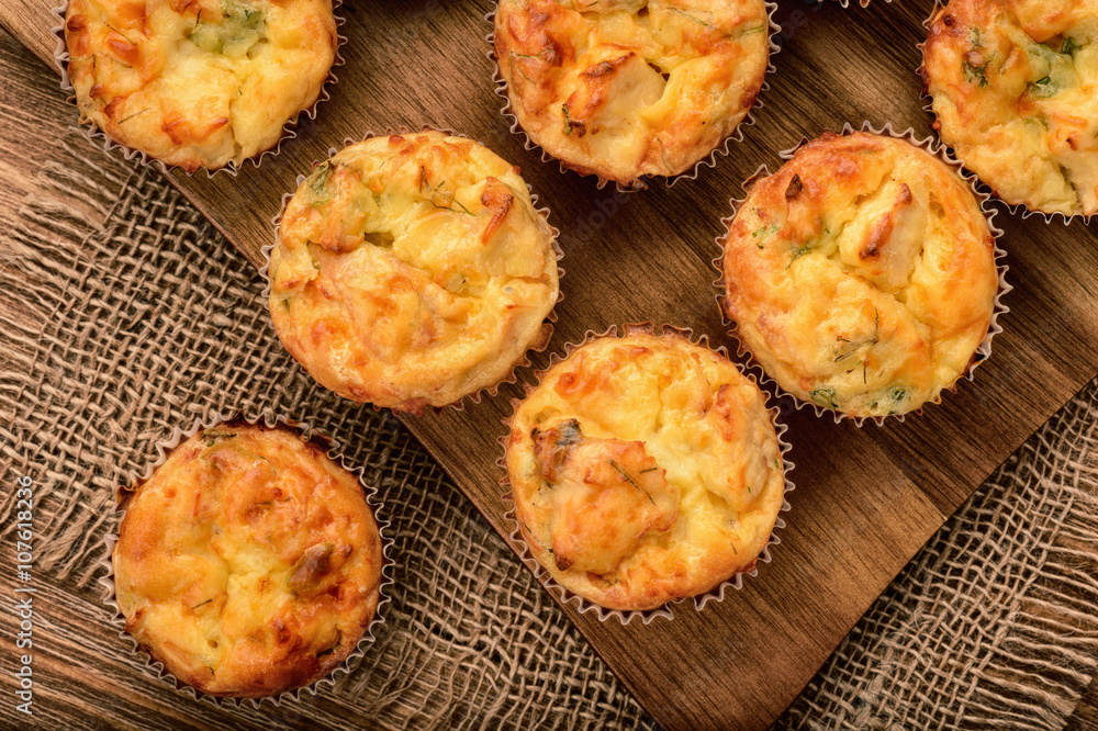 Homemade muffins with chicken and cheese on brown wooden board. Homemade muffins with chicken and cheese on brown wooden board.