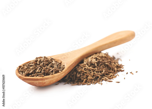 Wooden spoon over the pile of cumin photo