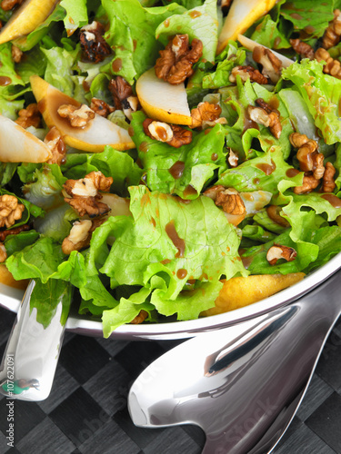 Iceberg salad with walnuts and pears, close up, vertical shot photo