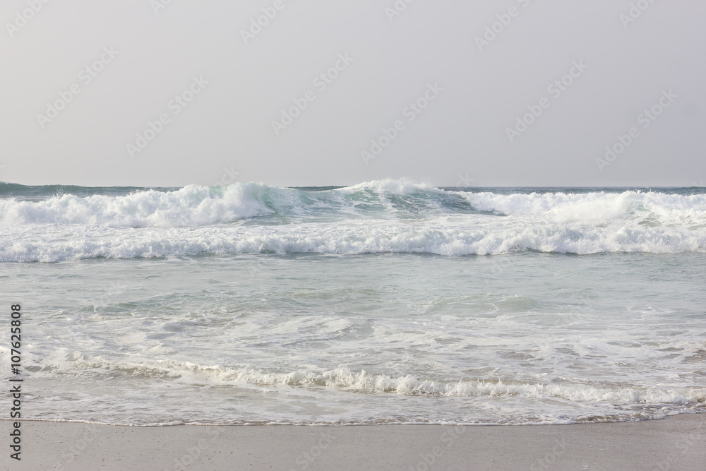 Waves with white foam on the shore Waves with white foam on the shore