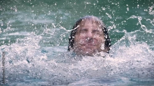 Slow motion CU of a man drowning in water - a swimming pool, lake, or ocean