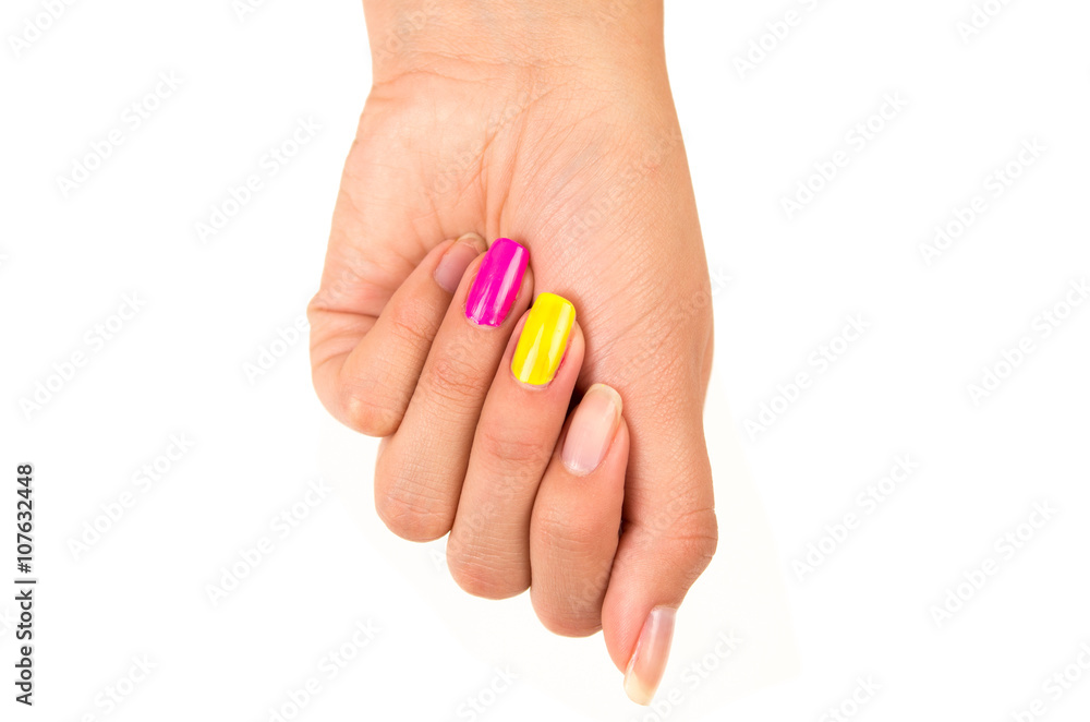 Hand with closed fist closeup nails visible in different colors pink, yellow and natural, white background Hand with closed fist closeup nails visible in different colors pink, yellow and natural, white background