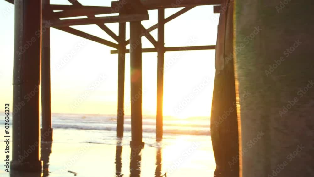 SLOW MOTION Woman Running on the Beach Under Pier at Sunset. Healthy Active Lifestyle SLOW MOTION Woman Running on the Beach Under Pier at Sunset. Healthy Active Lifestyle