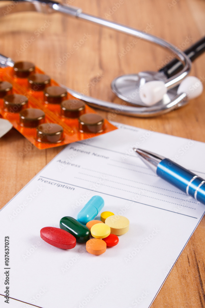 Medical pills, tablets or supplements with prescription and stethoscope, health care concept Medical pills, tablets or supplements with prescription and stethoscope, health care concept