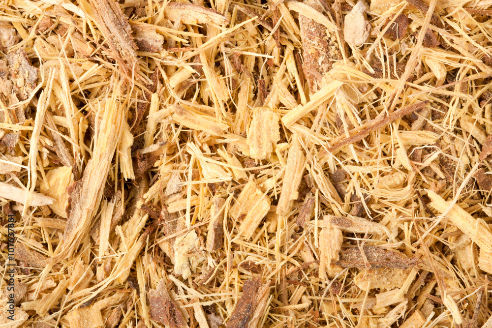 Dried licorice root is grated as a background close-up 