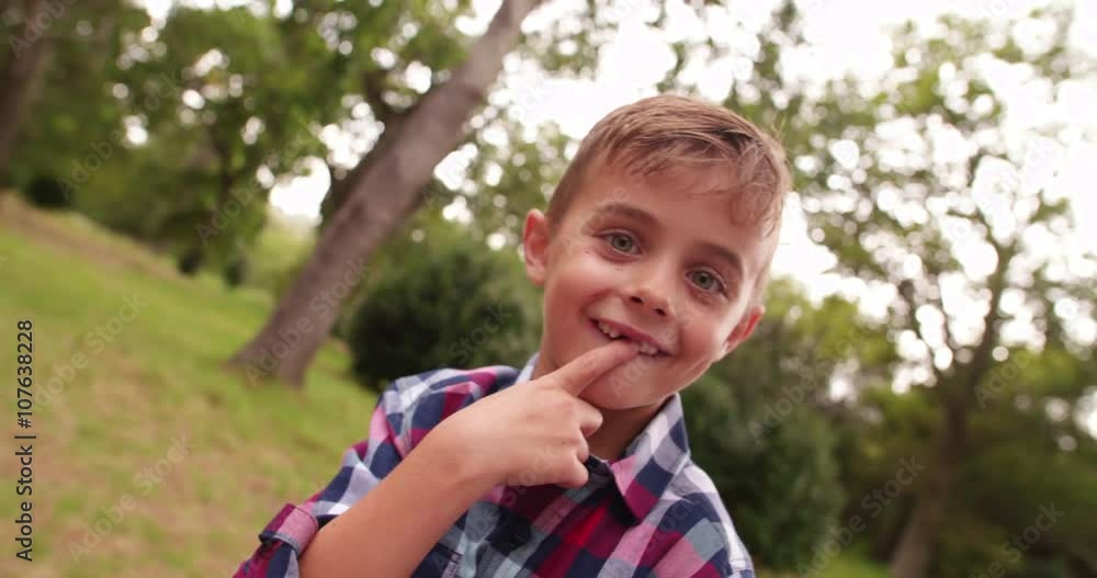 Cute little Boy in park smiling and looking at camera 