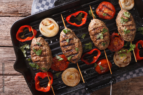 Kofta kebab with grilled vegetables on the grill pan close-up. horizontal top view 