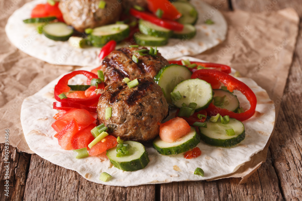 Grilled meat balls with fresh vegetables on a flat bread close up. horizontal
Grilled meat balls with fresh vegetables on a flat bread close up. horizontal