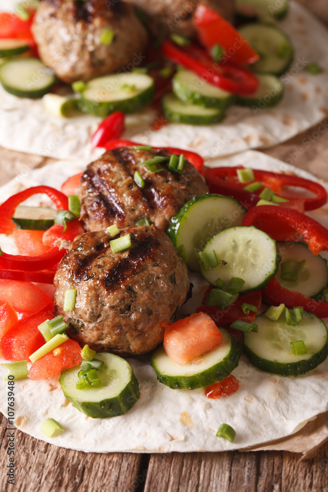 Turkish kofta with fresh vegetables on a flat bread close up. Vertical
Turkish kofta with fresh vegetables on a flat bread close up. Vertical