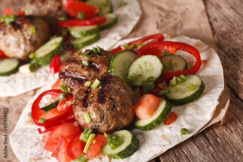 Arabian food: meat balls with fresh vegetables on a flat bread closeup. horizontal
