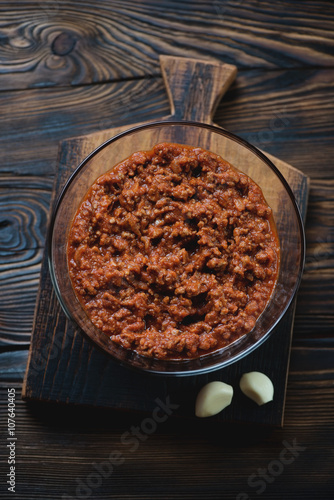 Glass bowl with bolognese sauce in a rustic wooden setting