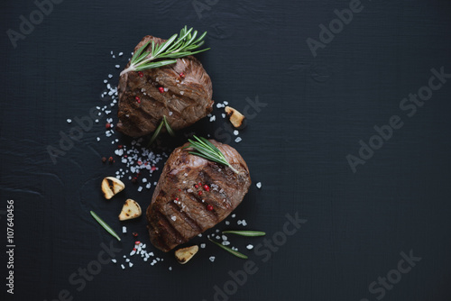 Foto Top view of grilled filet mignon steaks, black wooden surface