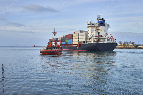 Big ship with escorting tugs leaving port