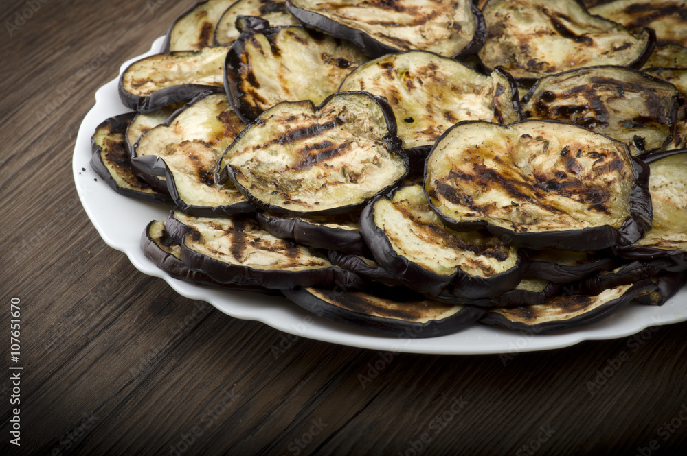 Aubergines eggplants and slices grilled on the plate Aubergines eggplants and slices grilled on the plate