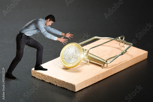 Man trying to pick a gold coin photo