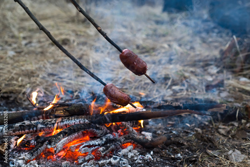 Sausages on the stick grilled in the fire