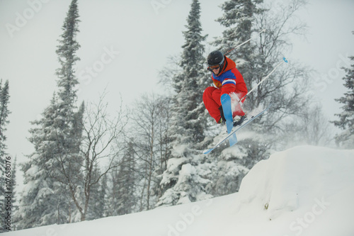 Extreme downhill skier on the snow in forest.