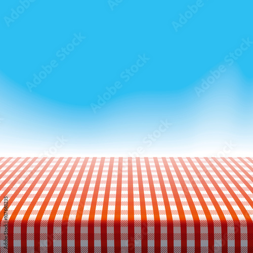 Vector picnic table covered with tablecloth on blue sky background with blurred clouds.