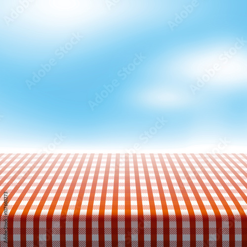 Vector picnic table covered with tablecloth on blue sky background with blurred clouds.