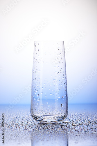 Empty drinking glass in drops of water