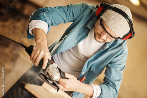 Obraz na plátně Carpenter working with power sander
