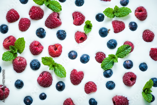 Food background, raspberries and blueberies on yoghurt