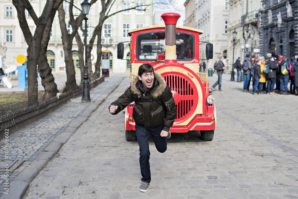 Obraz premium Man with a laugh escapes from the red train