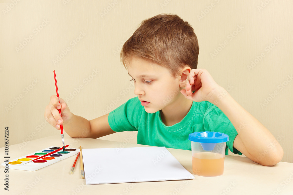 Beginner artist in a green shirt going to paint watercolors Beginner artist in a green shirt going to paint watercolors