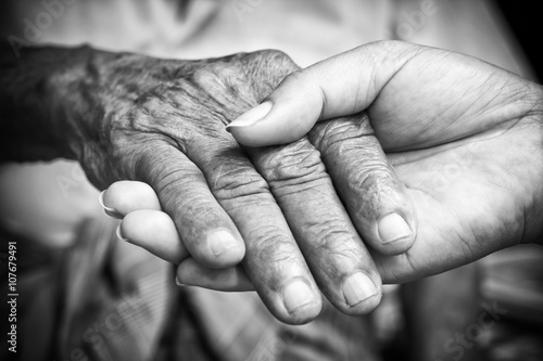 Senior and young holding hands