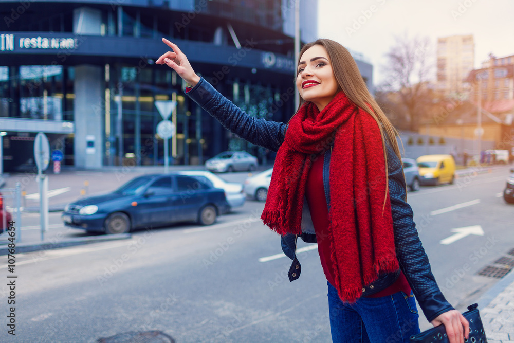 Fashion shot of pretty young woman over city background, wearing red scarf. City lifestyle. Female fashion Fashion shot of pretty young woman over city background, wearing red scarf. City lifestyle. Female fashion