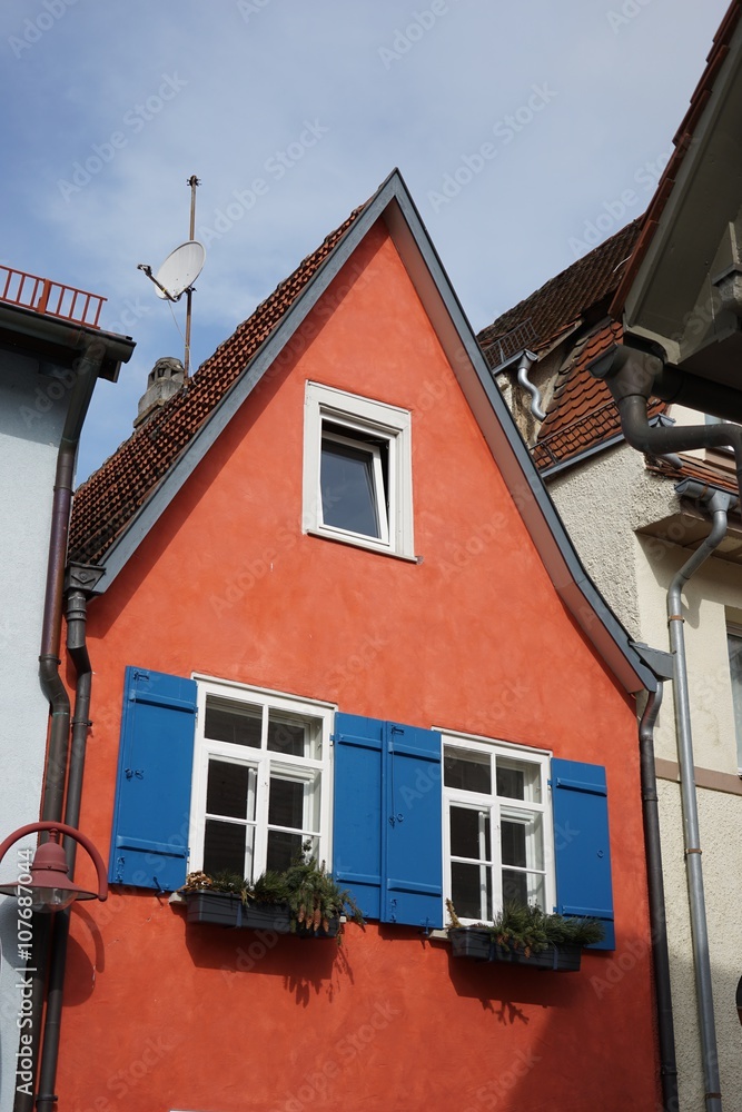 Schmales rotes Fachwerkhaus mit blauen Fensterläden