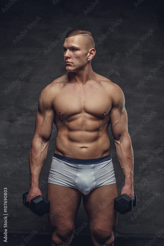 A man  in a white panties holds a pair of dumbbells.