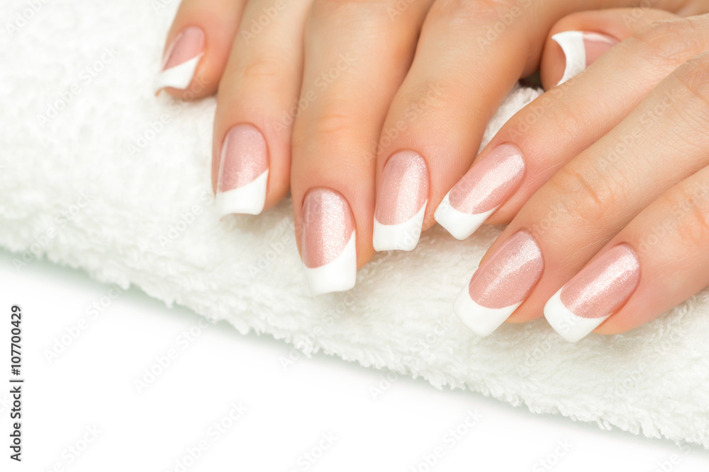 Beautiful fingers with french manicure on the towel. Manicure in Beautiful fingers with french manicure on the towel. Manicure in