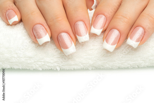 Photos Beautiful fingers with french manicure on the towel. Manicure in