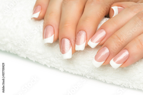 Beautiful fingers with french manicure on the towel. Manicure in