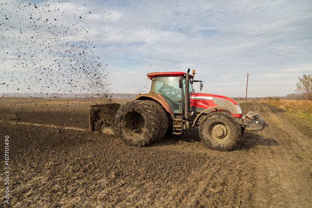 Fototapeta premium Tractor with double wheeled ditcher digging drainage canal