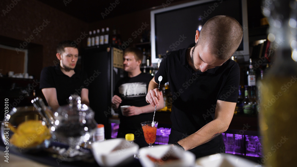 Bartender is making cocktail at bar counter, Night club