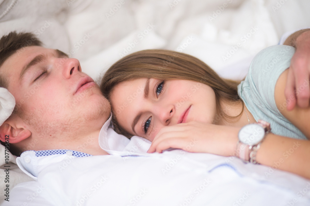 Young love couple in bed. Girl lying on the boy's shoulder Young love couple in bed. Girl lying on the boy's shoulder