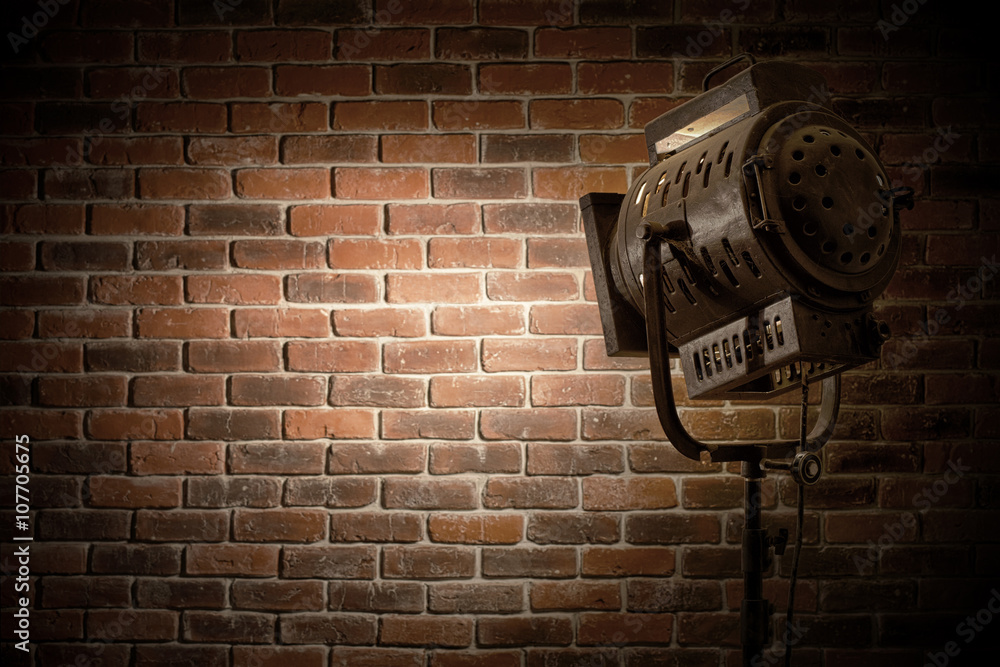 vintage theatre/movie spot light focused on a brick wall background