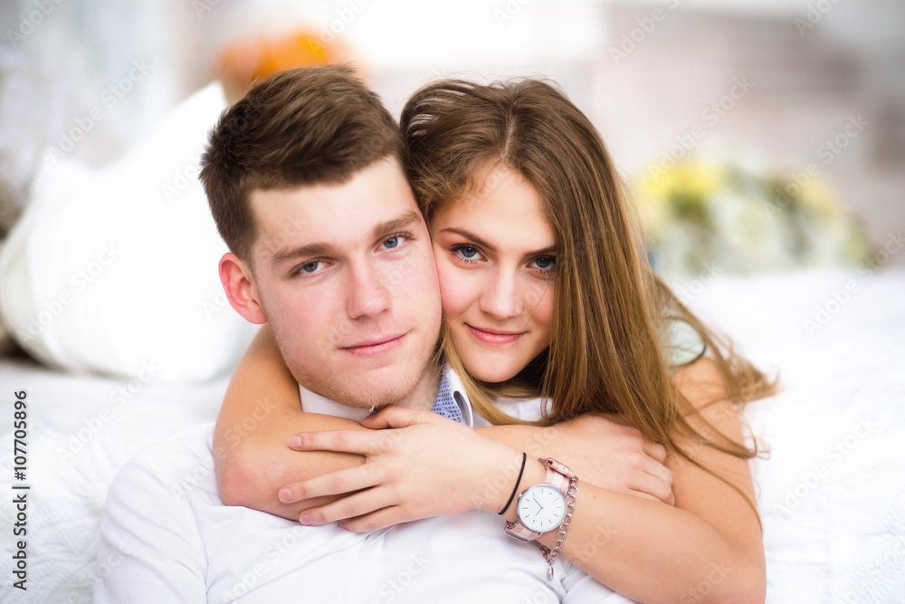 Happy girl in love at home embracing boyfriend