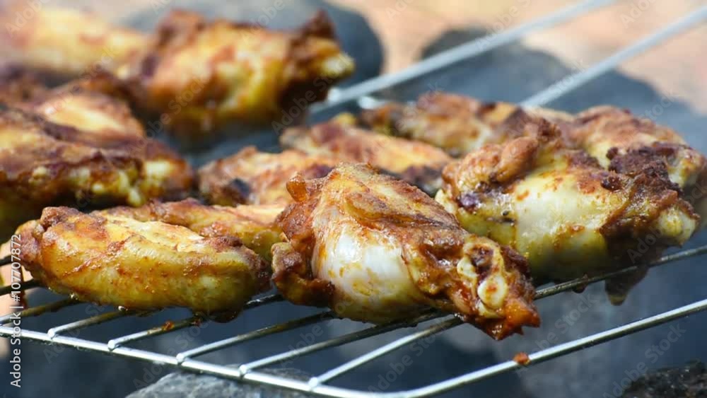 Chicken wings and legs cooking on a barbecue grill, closeup. Outdoor cooking. Chicken wings and legs cooking on a barbecue grill, closeup. Outdoor cooking.