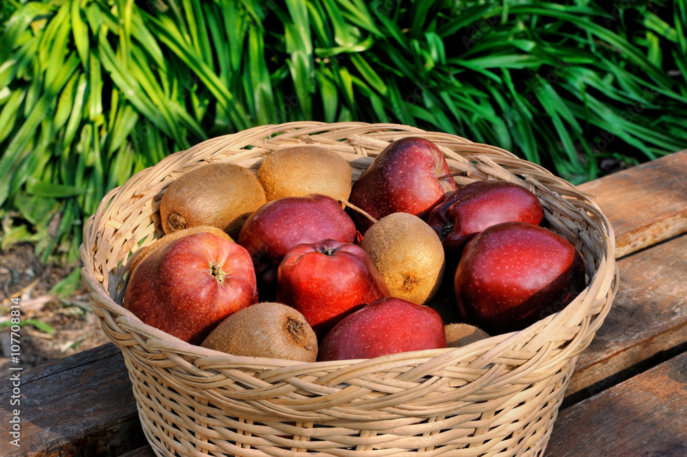 Obraz premium red apples and kiwi in basket