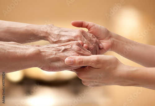 Female hands touching old male hand